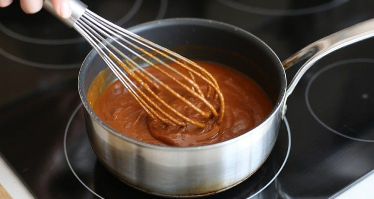 Buffalo sauce being whisked in a saucepan over low heat until smooth and glossy Buffalo sauce being whisked in a saucepan over low heat until smooth and glossy