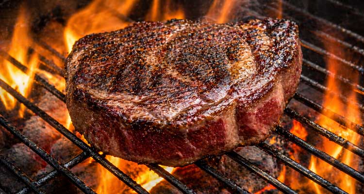 Charcoal grill searing a steak Charcoal grill searing a steak
