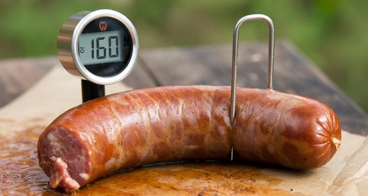 Meat thermometer inserted in a smoked bratwurst reading 160 degrees F Meat thermometer inserted in a smoked bratwurst reading 160 degrees F