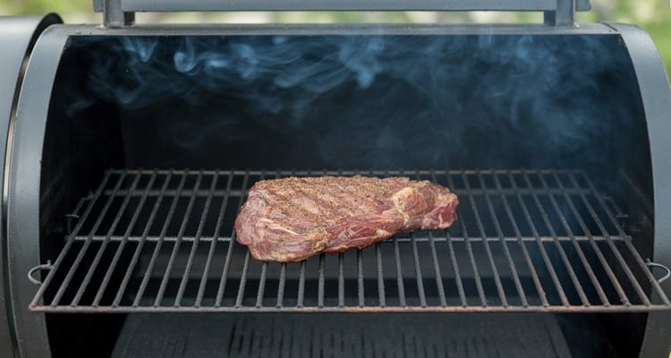 Smoking flank steak on pellet grill Seasoned flank steak smoking on pellet grill grates